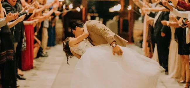 Un couple de jeunes mariés s'embrassant lors de la première danse.
